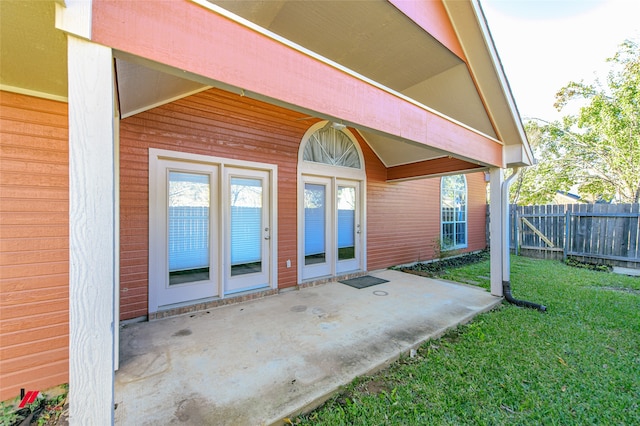 property entrance with a yard and a patio