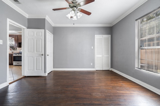 unfurnished room with ceiling fan, dark hardwood / wood-style flooring, and ornamental molding