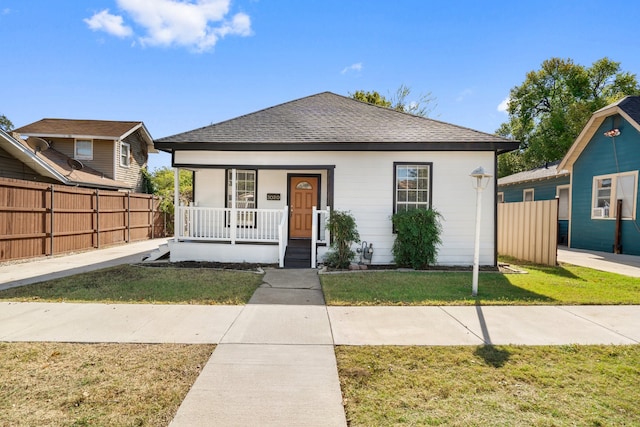 bungalow-style home featuring covered porch and a front yard