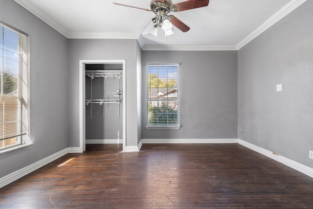 unfurnished bedroom featuring ceiling fan, crown molding, dark wood-type flooring, and a closet