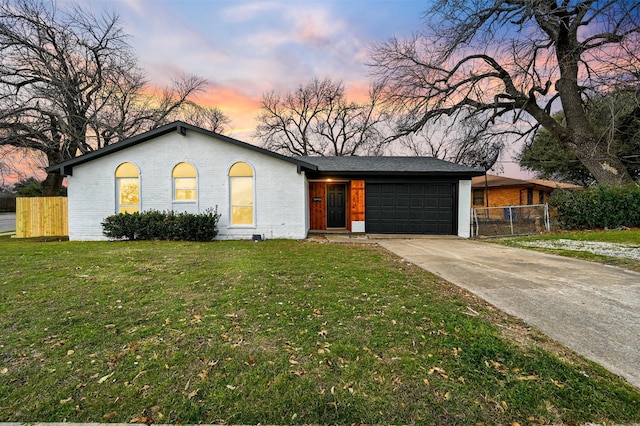 ranch-style house featuring a lawn and a garage