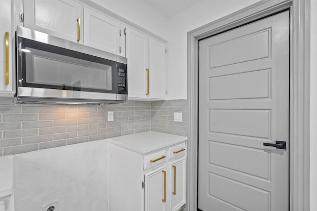 kitchen featuring backsplash and white cabinets