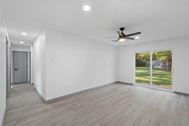 empty room with ceiling fan and light hardwood / wood-style flooring