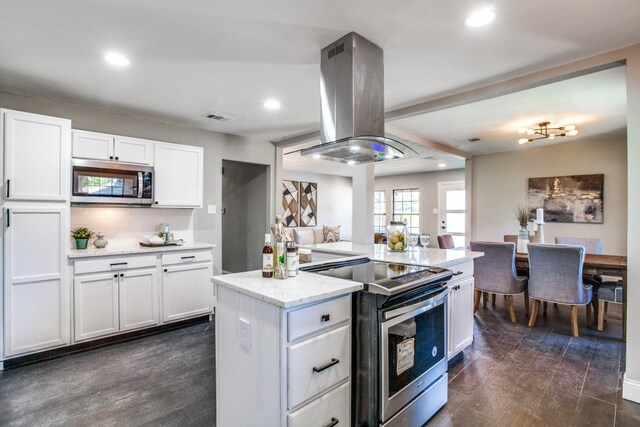 kitchen with island exhaust hood, white cabinetry, dark hardwood / wood-style floors, and appliances with stainless steel finishes