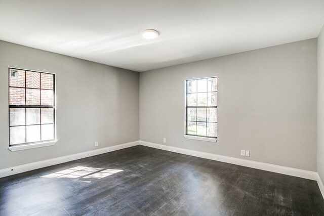 unfurnished room with dark hardwood / wood-style flooring