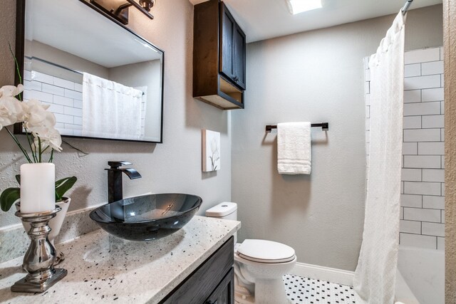 full bathroom featuring vanity, shower / tub combo, and toilet