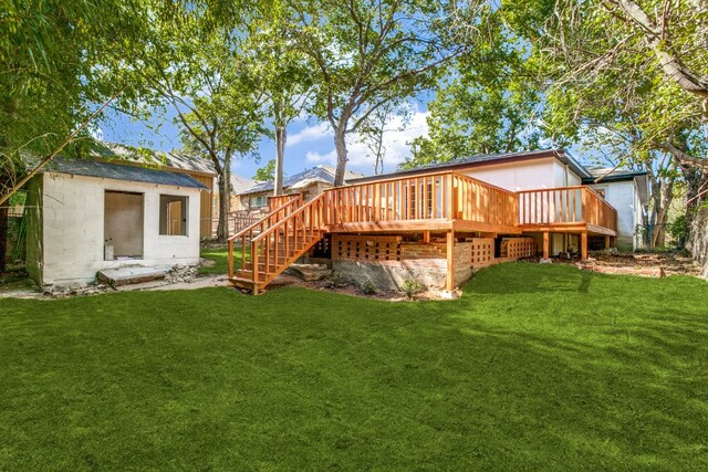 back of property featuring an outbuilding, a lawn, and a wooden deck