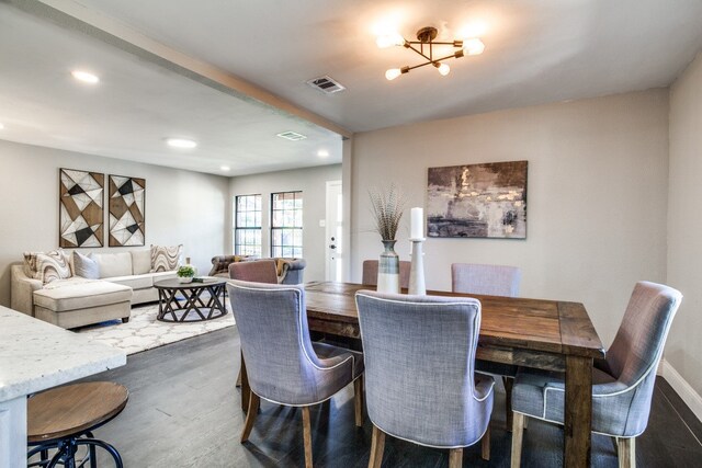 dining space featuring an inviting chandelier and dark wood-type flooring