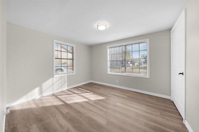 unfurnished room featuring light hardwood / wood-style floors and a wealth of natural light