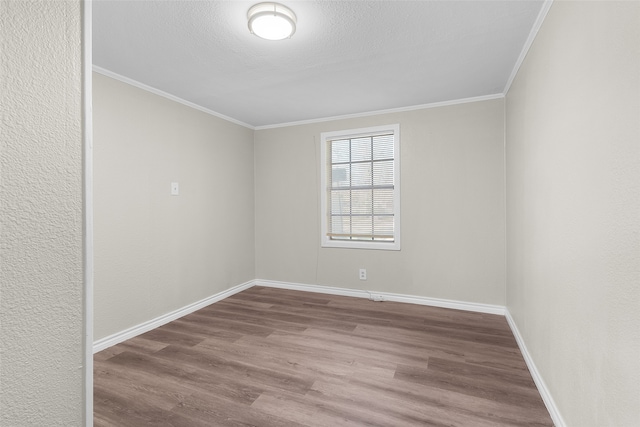 empty room featuring hardwood / wood-style floors and crown molding