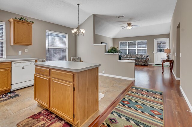 kitchen with light wood-type flooring, ceiling fan with notable chandelier, dishwasher, a kitchen island, and lofted ceiling