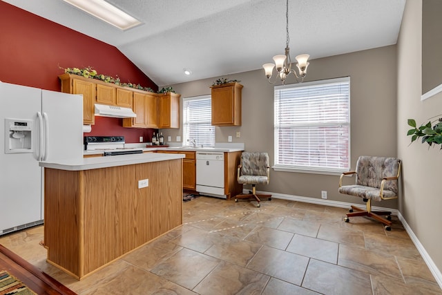 kitchen with pendant lighting, a center island, white appliances, vaulted ceiling, and a notable chandelier