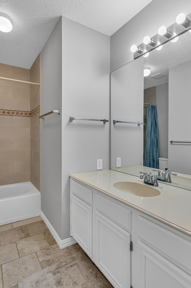 bathroom with vanity, shower / bath combo, and a textured ceiling