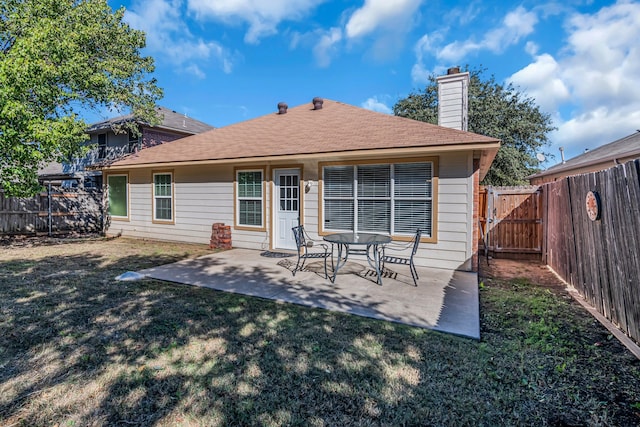 back of house with a yard and a patio