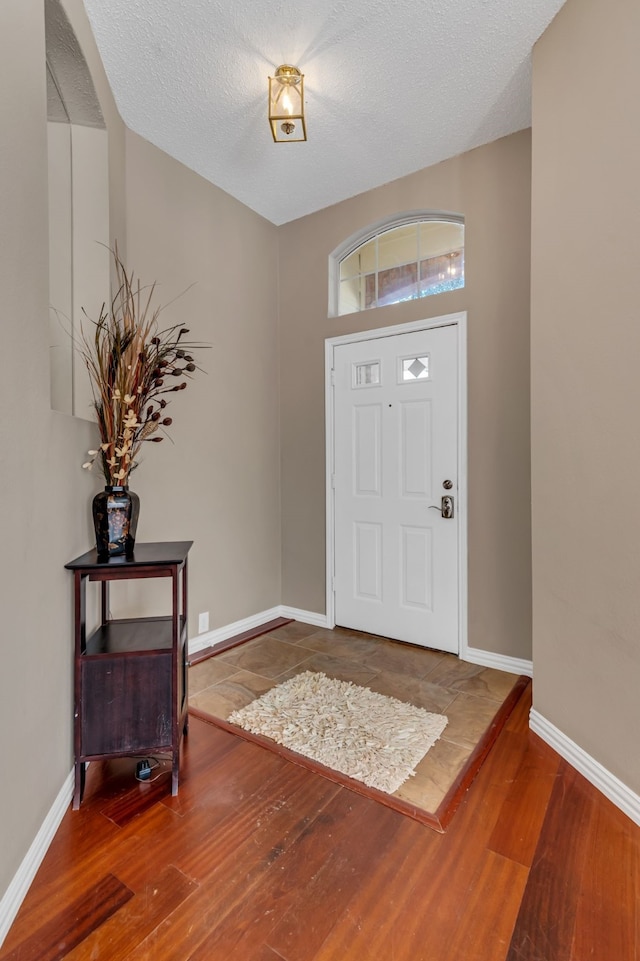 entryway with a textured ceiling and hardwood / wood-style flooring