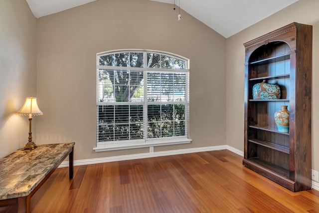 unfurnished room featuring wood-type flooring and lofted ceiling