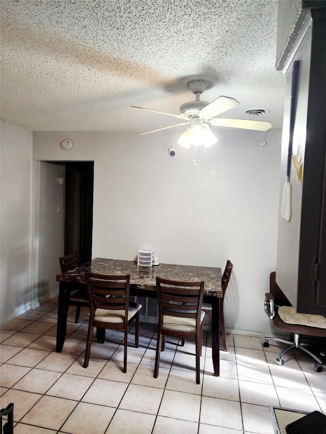 dining space with light tile patterned floors, a textured ceiling, and ceiling fan