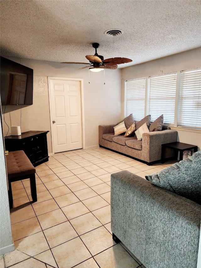 tiled living room with ceiling fan and a textured ceiling