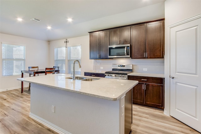 1805 Gold Mine Trl, Aubrey, TX 76227 - kitchen featuring a center island with sink, sink, light wood-type flooring, and stainless steel appliances
