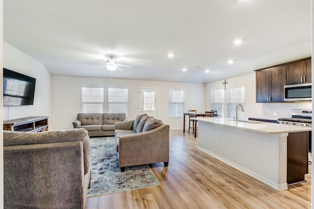 living room with ceiling fan, a healthy amount of sunlight, light wood-type flooring, and sink