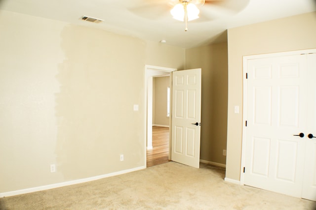 unfurnished bedroom with light carpet and ceiling fan