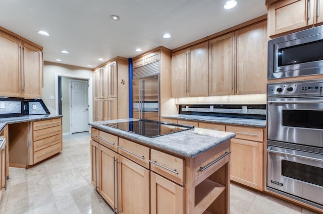 kitchen with light brown cabinetry, tasteful backsplash, built in appliances, a kitchen island, and light tile patterned flooring