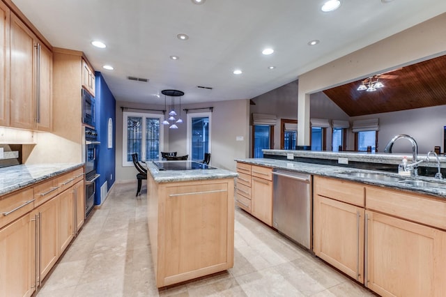 kitchen featuring light stone counters, black appliances, sink, a center island, and hanging light fixtures