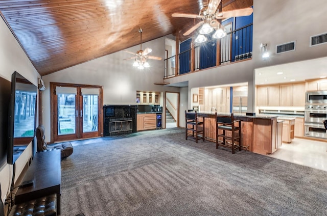 living room featuring dark carpet, high vaulted ceiling, ceiling fan, and wooden ceiling