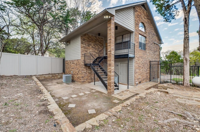 back of house with central AC unit