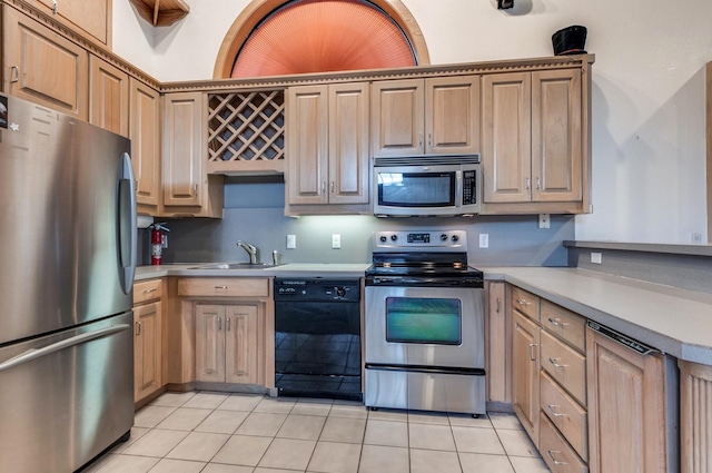 kitchen featuring appliances with stainless steel finishes, light tile patterned floors, and sink