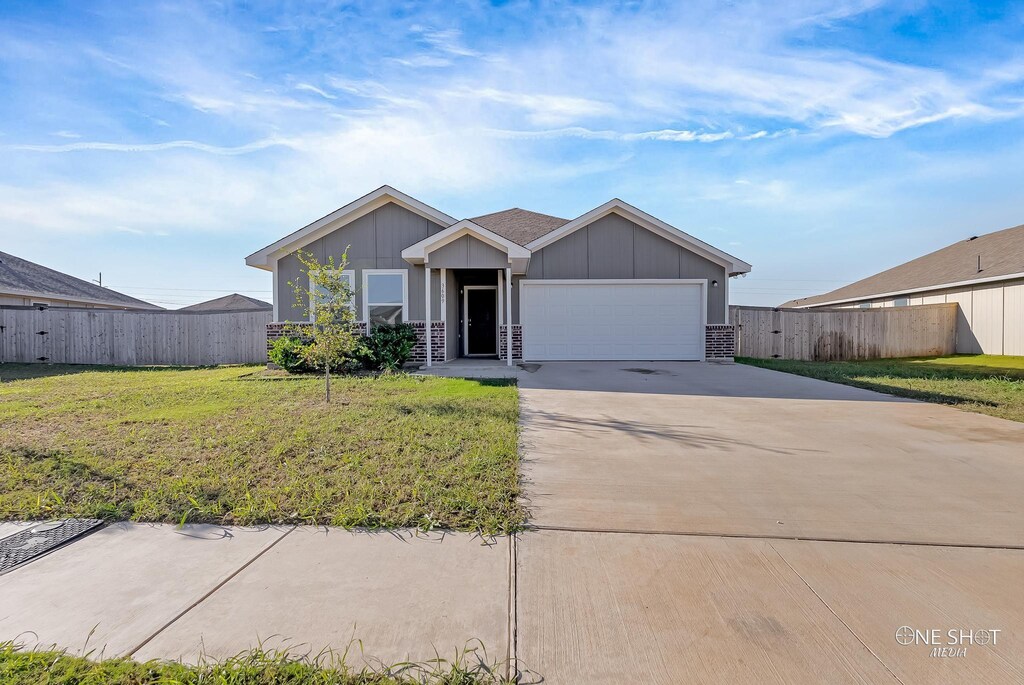 view of front of home with a garage and a front lawn