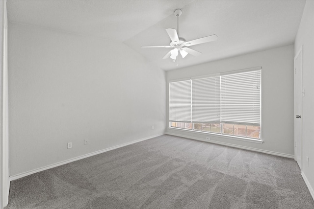 carpeted spare room featuring vaulted ceiling and ceiling fan