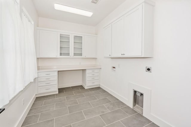 clothes washing area with cabinets, hookup for a washing machine, hookup for an electric dryer, and light tile patterned floors