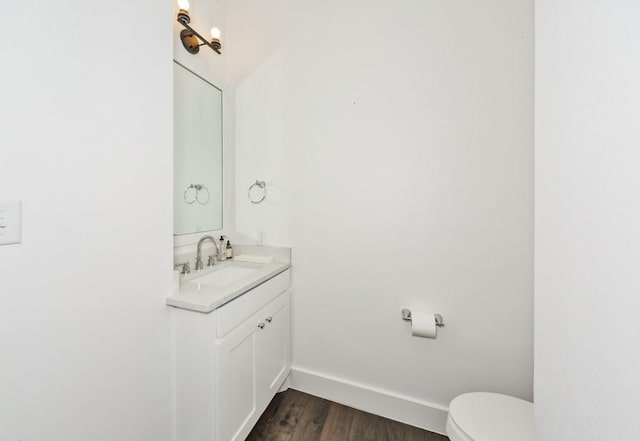 bathroom with hardwood / wood-style flooring, vanity, and toilet