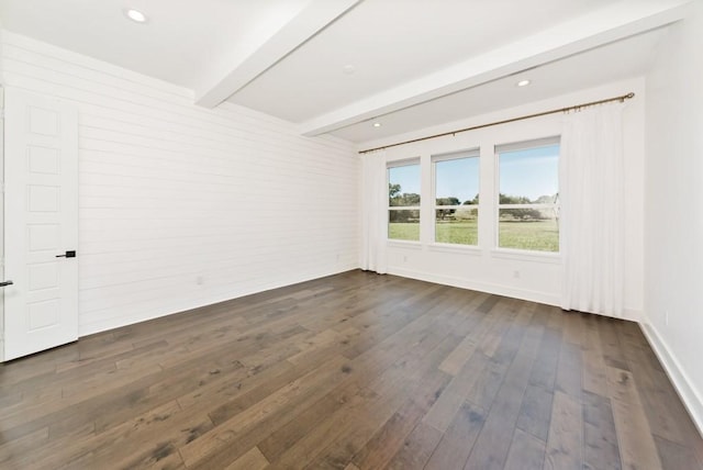 unfurnished room featuring beamed ceiling and dark hardwood / wood-style floors