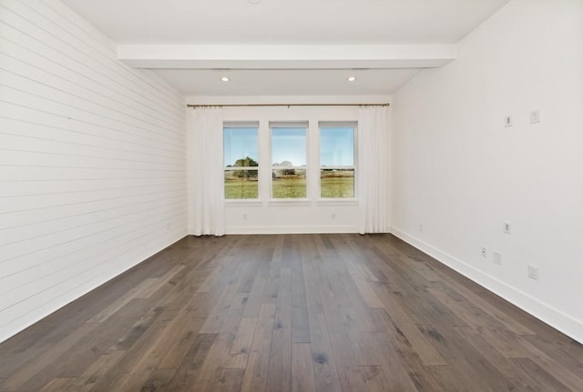 empty room featuring beamed ceiling and dark wood-type flooring