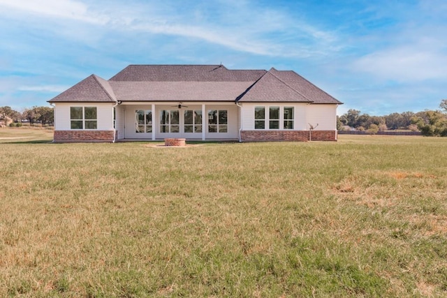 back of house featuring ceiling fan and a yard