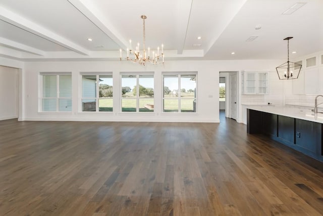 unfurnished living room with beam ceiling, a notable chandelier, and dark hardwood / wood-style flooring