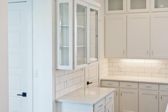 kitchen with decorative backsplash and white cabinets