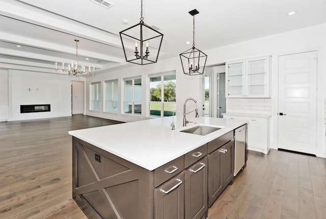 kitchen featuring white cabinetry, sink, beam ceiling, and hanging light fixtures