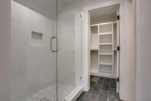 bathroom featuring walk in shower, tile patterned floors, and vaulted ceiling