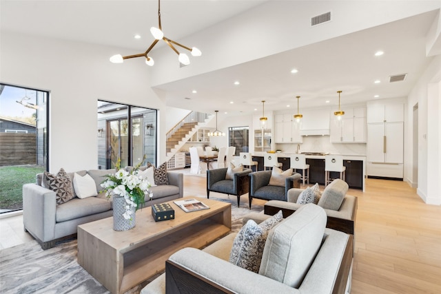 living room featuring an inviting chandelier and light wood-type flooring