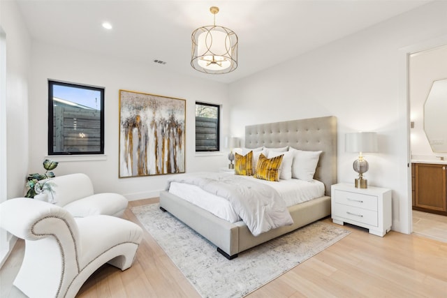 bedroom featuring light hardwood / wood-style flooring and a chandelier