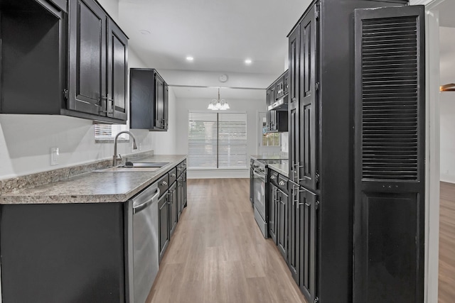 kitchen with appliances with stainless steel finishes, light wood-type flooring, sink, decorative light fixtures, and a chandelier