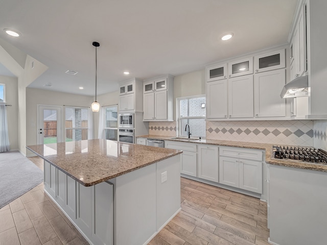 kitchen with white cabinetry, sink, a kitchen island, and appliances with stainless steel finishes