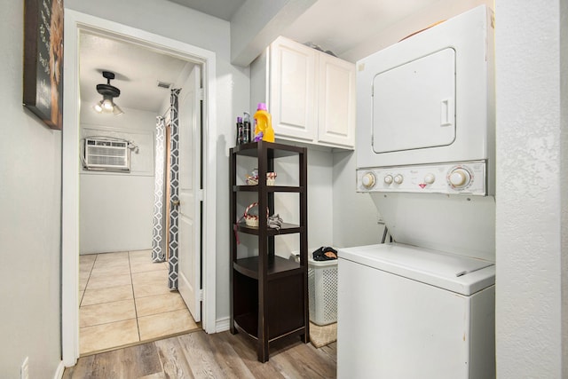 washroom with light wood-type flooring, cabinets, a wall mounted AC, and stacked washing maching and dryer