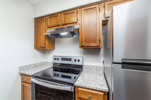 kitchen with light stone counters and appliances with stainless steel finishes