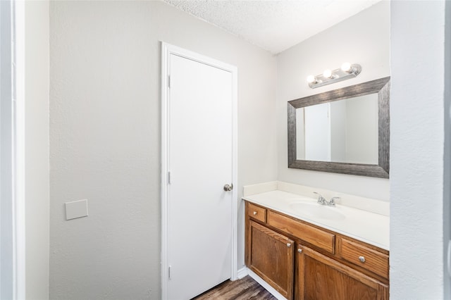 bathroom with vanity, a textured ceiling, and hardwood / wood-style flooring