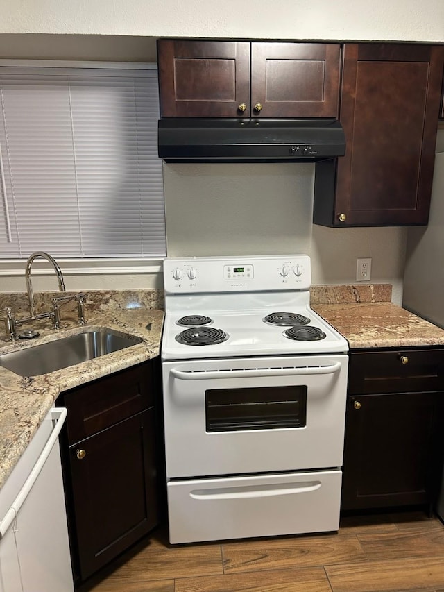 kitchen with hardwood / wood-style floors, dark brown cabinetry, white appliances, and sink