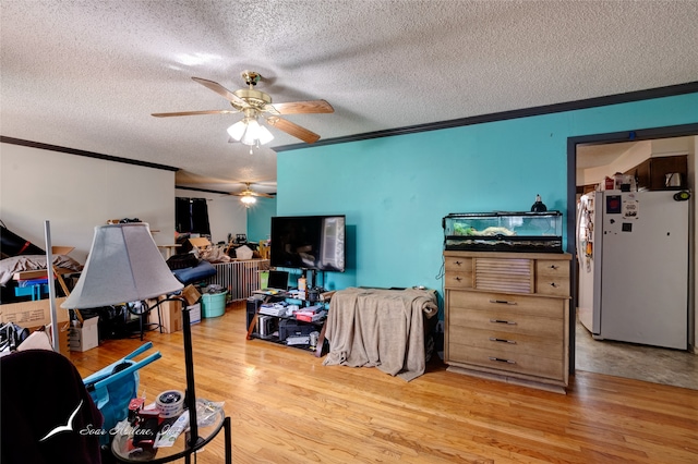 interior space featuring a textured ceiling, ceiling fan, crown molding, white refrigerator, and hardwood / wood-style flooring